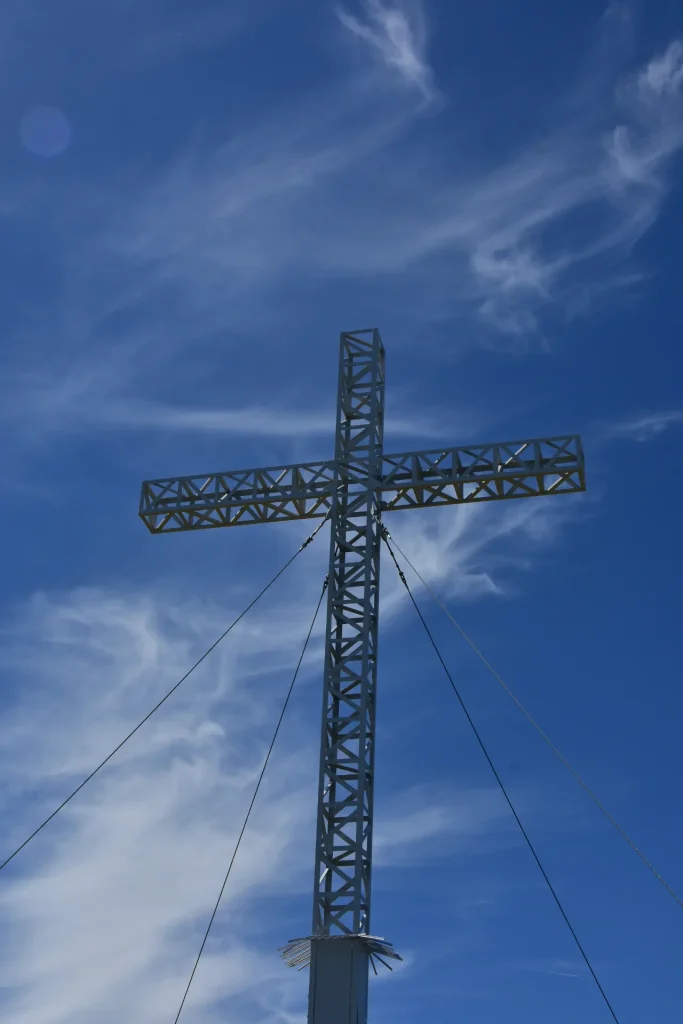 La croix du Grand COlombier avec un fon bleu et une traine de nuage