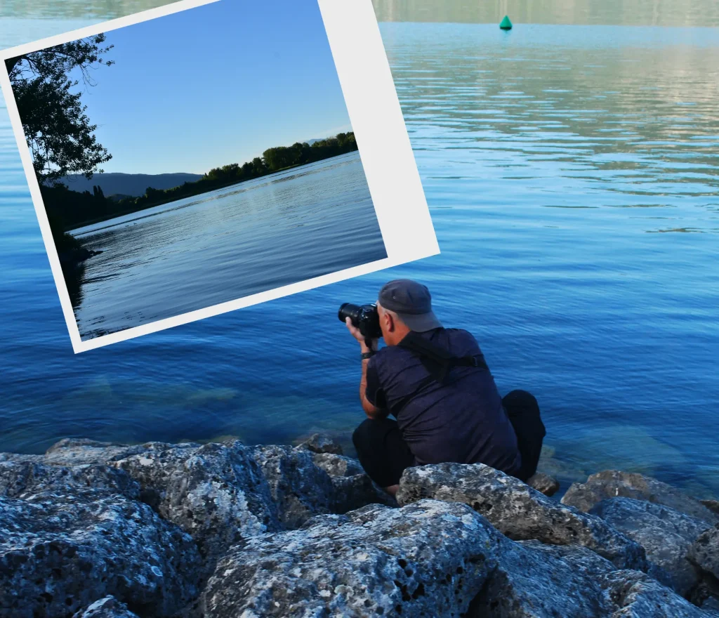 Pris en train de photographier le paysage de la Chautagne depuis Conjux. Je suis descendu au raz de l'eau via les pierres de la jetée La photo prise est incrustée dans un format polaroid. On y voit le bout du lac du Bourget côté Chautagne à la tombée du jour