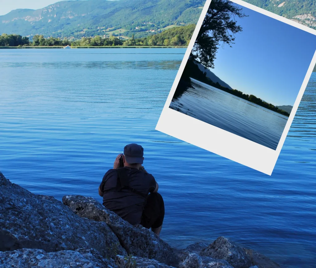 Pris en train de photographier le paysage de la Chautagne depuis Conjux. Je suis descendu au raz de l'eau via les pierres de la jetée La photo prise est incrustée dans un format polaroid. On y voit le bout du lac du Bourget côté Chautagne à la tombée du jour