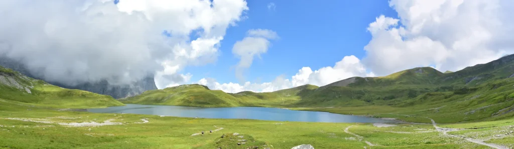 Lac d'Anterne vue à la descente du col d'Anterne au niveau du lac avec les Fiz ennuagées sur la gauche et un beau ciel bleu en face